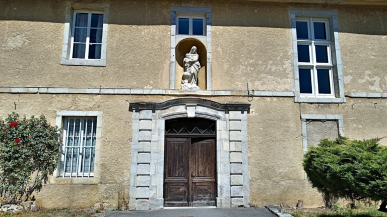 Entrée d’un bâtiment conventuel surmontée d’une statue de la Vierge à l’Enfant à l’abbaye de la Grâce-Dieu